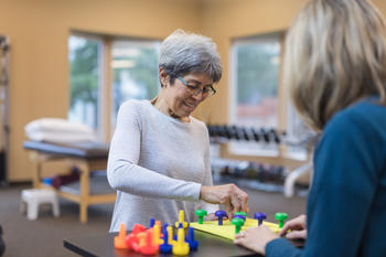 Occupational therapist works with an elderly woman